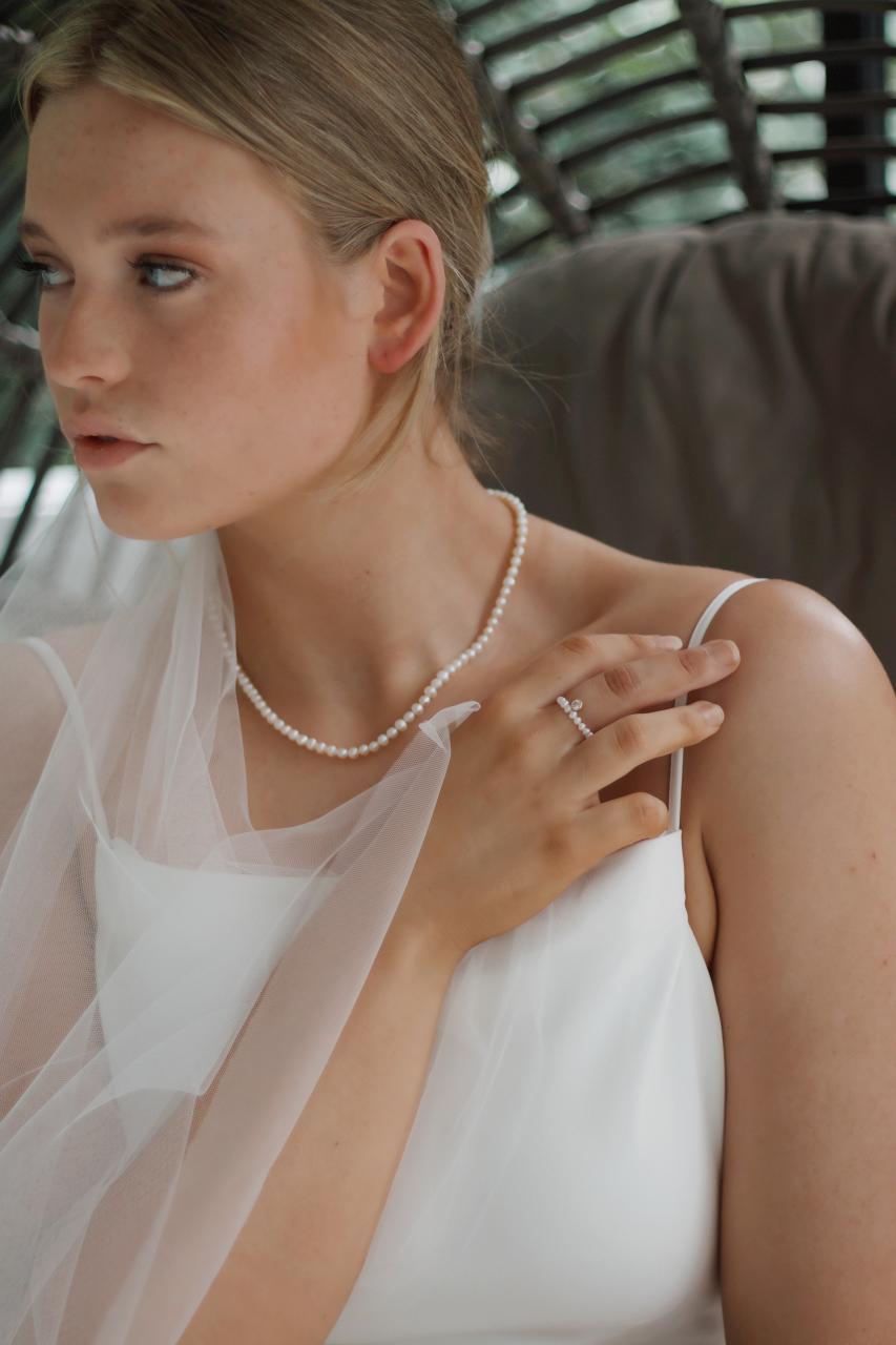woman in white tank top wearing silver necklace
